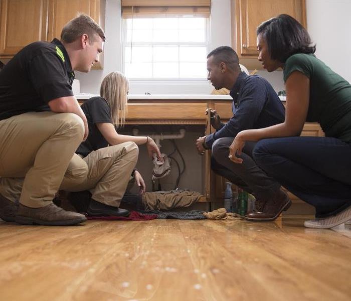 SERVPRO Technicians speaking with customers about water damage and potential mold.